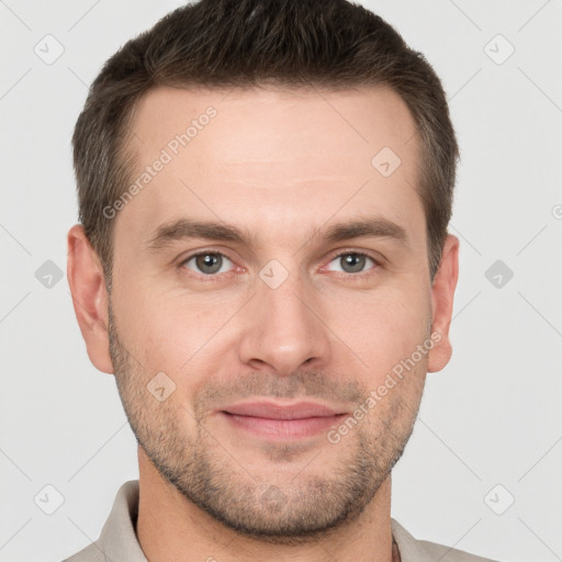 Joyful white young-adult male with short  brown hair and grey eyes