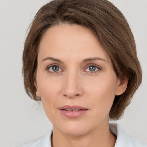 Joyful white adult female with medium  brown hair and grey eyes