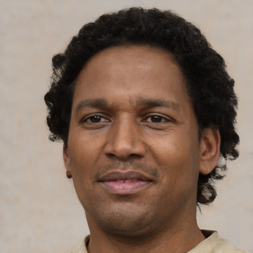 Joyful black young-adult male with short  brown hair and brown eyes