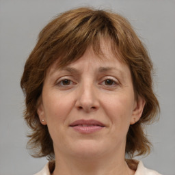 Joyful white adult female with medium  brown hair and grey eyes