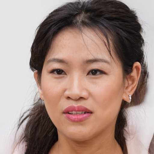 Joyful asian adult female with medium  brown hair and brown eyes
