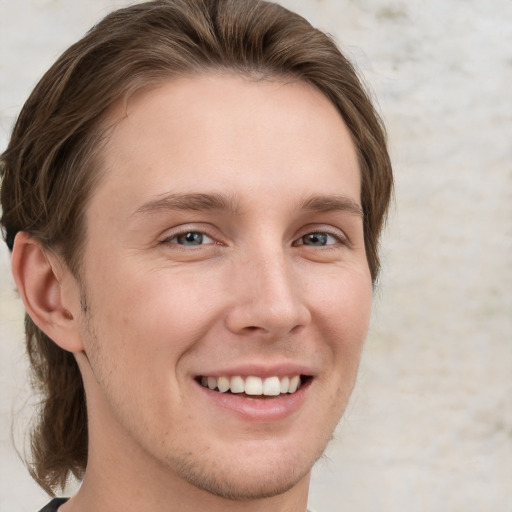 Joyful white young-adult male with medium  brown hair and grey eyes