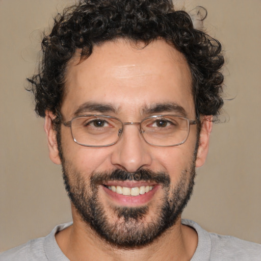 Joyful white adult male with short  black hair and brown eyes