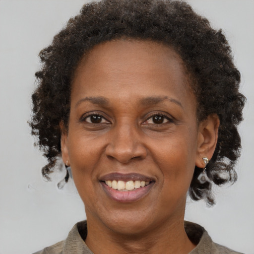 Joyful black adult female with short  brown hair and brown eyes