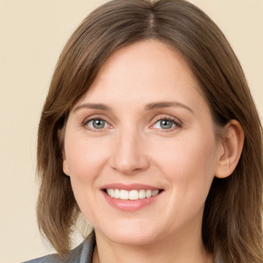 Joyful white young-adult female with long  brown hair and grey eyes