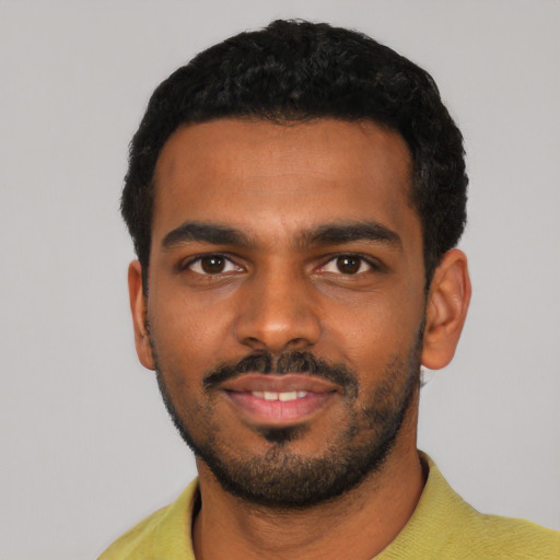 Joyful black young-adult male with short  black hair and brown eyes