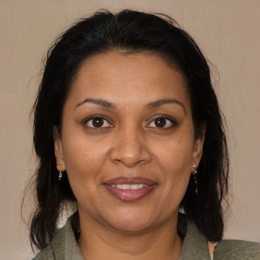 Joyful latino adult female with medium  brown hair and brown eyes