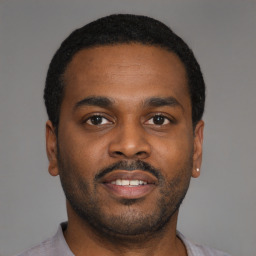 Joyful black young-adult male with short  black hair and brown eyes