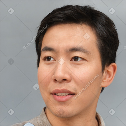 Joyful asian young-adult male with short  brown hair and brown eyes