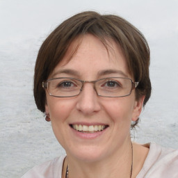 Joyful white adult female with medium  brown hair and blue eyes