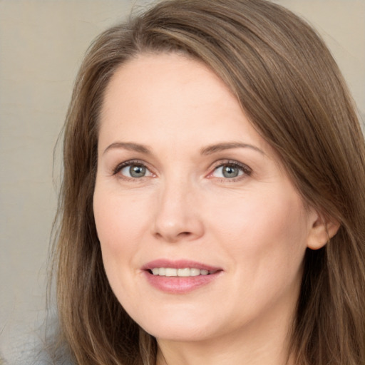 Joyful white adult female with long  brown hair and brown eyes