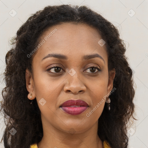 Joyful black young-adult female with long  brown hair and brown eyes
