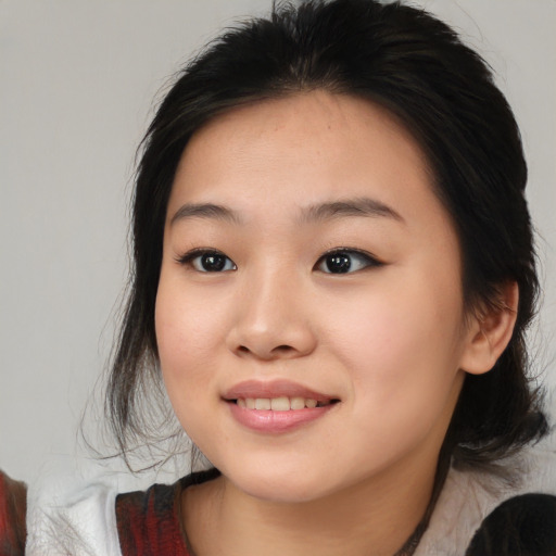Joyful asian young-adult female with medium  black hair and brown eyes