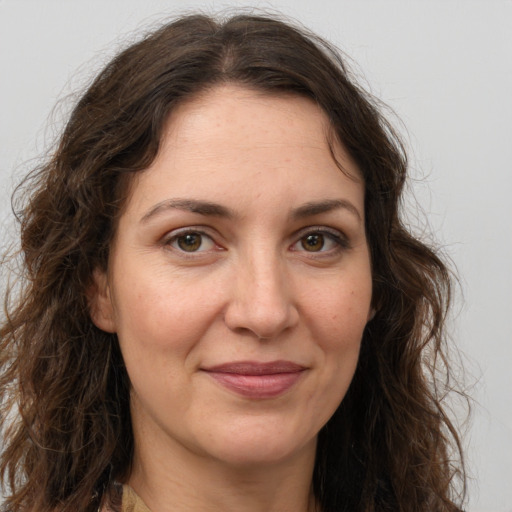 Joyful white adult female with long  brown hair and brown eyes