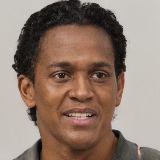 Joyful black adult male with short  black hair and brown eyes