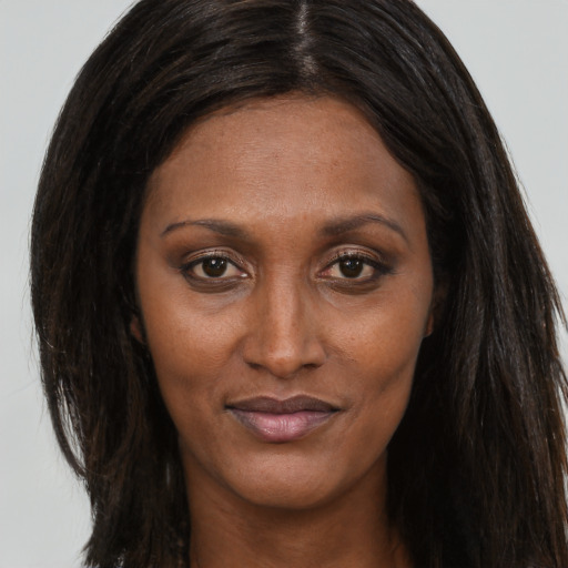 Joyful black adult female with long  brown hair and brown eyes