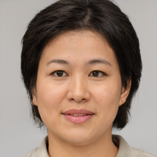 Joyful asian adult female with medium  brown hair and brown eyes