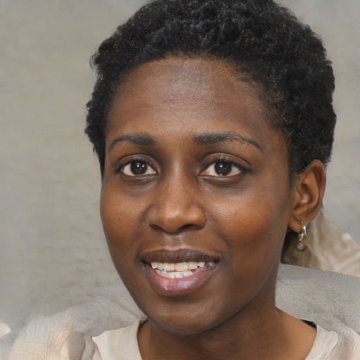 Joyful black young-adult female with short  black hair and brown eyes
