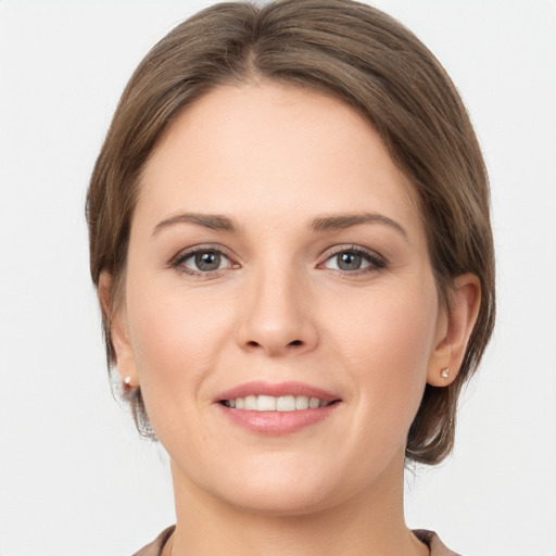 Joyful white young-adult female with medium  brown hair and grey eyes