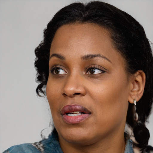 Joyful black adult female with medium  black hair and brown eyes
