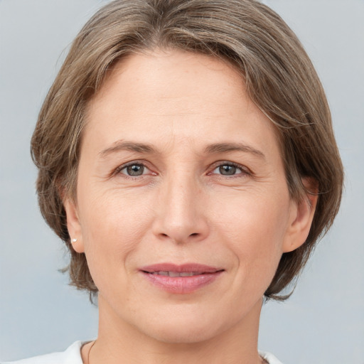 Joyful white adult female with medium  brown hair and grey eyes