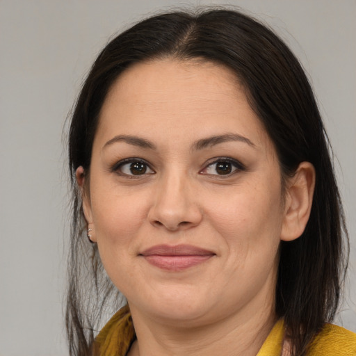 Joyful latino adult female with medium  brown hair and brown eyes