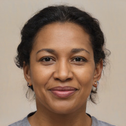 Joyful black adult female with medium  brown hair and brown eyes