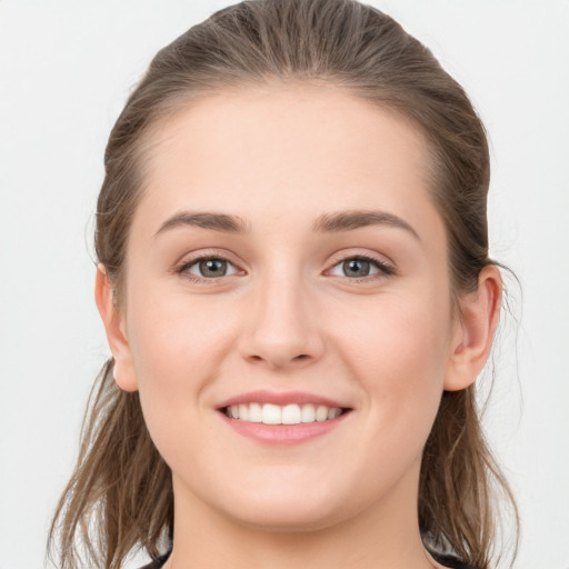 Joyful white young-adult female with long  brown hair and grey eyes