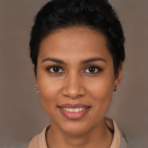 Joyful black young-adult female with short  brown hair and brown eyes