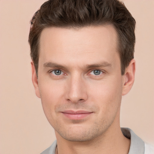 Joyful white young-adult male with short  brown hair and grey eyes