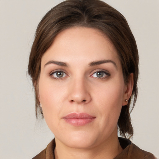 Joyful white young-adult female with medium  brown hair and grey eyes