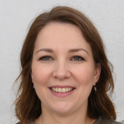 Joyful white adult female with medium  brown hair and brown eyes