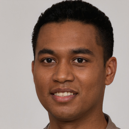 Joyful black young-adult male with short  black hair and brown eyes