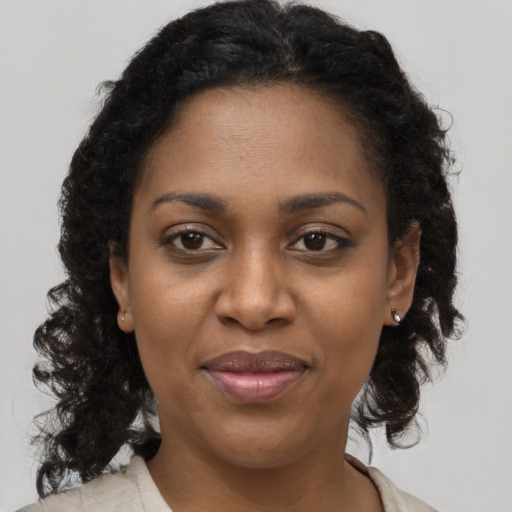 Joyful black adult female with long  brown hair and brown eyes