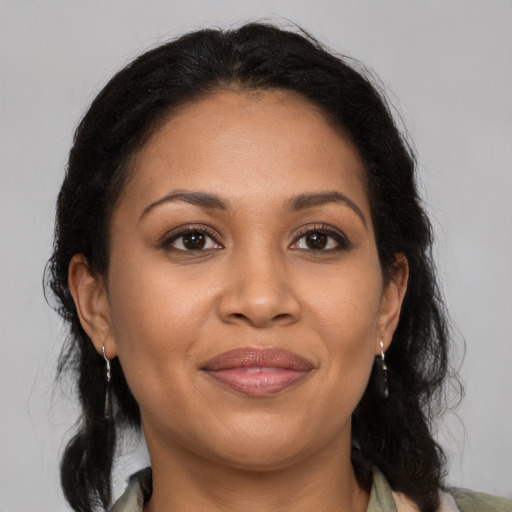 Joyful latino adult female with medium  brown hair and brown eyes