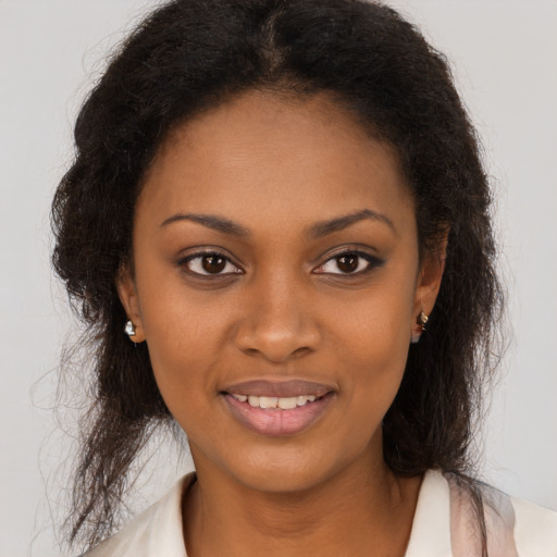 Joyful black young-adult female with long  brown hair and brown eyes