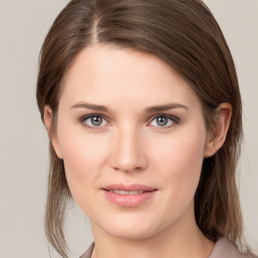 Joyful white young-adult female with medium  brown hair and grey eyes