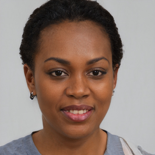 Joyful black young-adult female with short  brown hair and brown eyes
