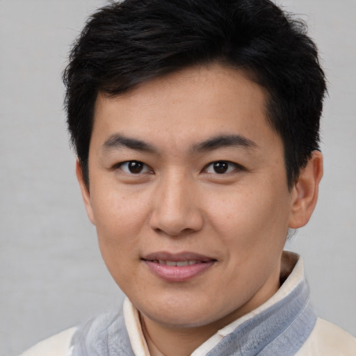 Joyful asian young-adult male with short  brown hair and brown eyes