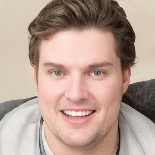 Joyful white young-adult male with short  brown hair and blue eyes