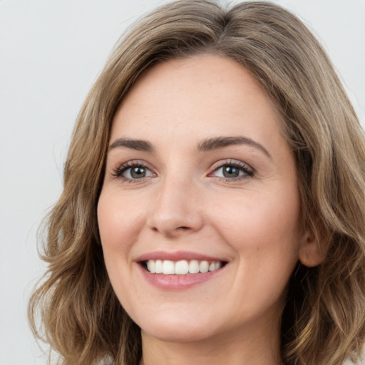 Joyful white young-adult female with long  brown hair and green eyes