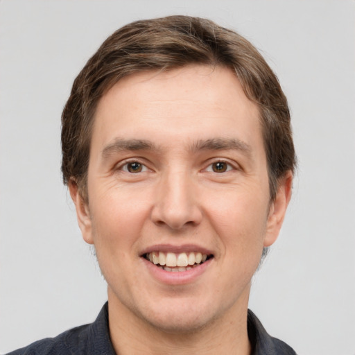 Joyful white adult male with short  brown hair and grey eyes