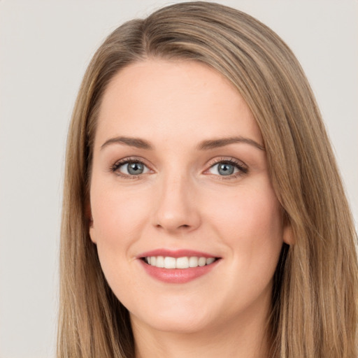 Joyful white young-adult female with long  brown hair and grey eyes