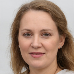 Joyful white adult female with long  brown hair and blue eyes