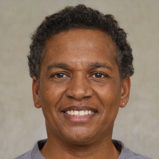 Joyful black adult male with short  black hair and brown eyes