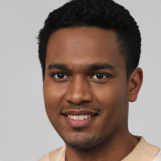 Joyful black young-adult male with short  black hair and brown eyes