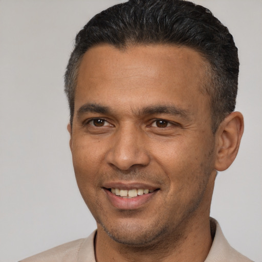 Joyful latino adult male with short  brown hair and brown eyes