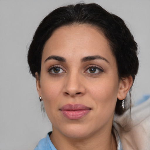 Joyful latino adult female with medium  brown hair and brown eyes