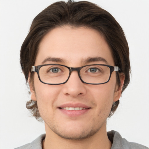 Joyful white young-adult male with short  brown hair and grey eyes