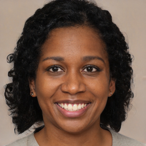 Joyful black young-adult female with medium  brown hair and brown eyes